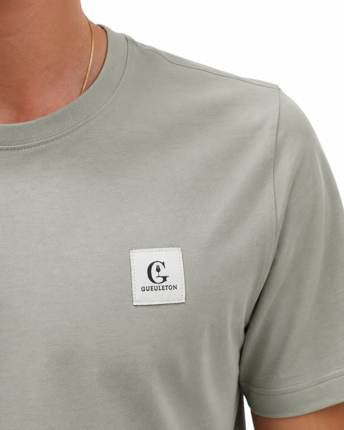 T-shirt_vert_sauge_Gueuleton_col_rond_manches_courtes_patch_tiss_logo_G_Gueuleton_sur_la_poitrine_gauche_coton_organique_180_g_m