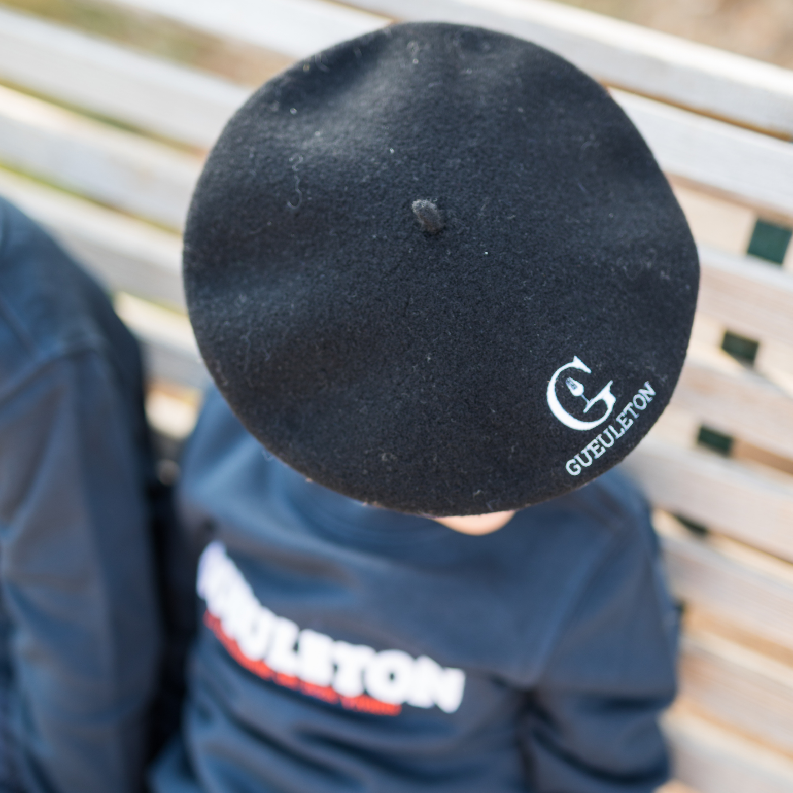 Béret Gueuleton enfant noir avec logo gravé, porté par un enfant en sweat Gueuleton - Gueuleton