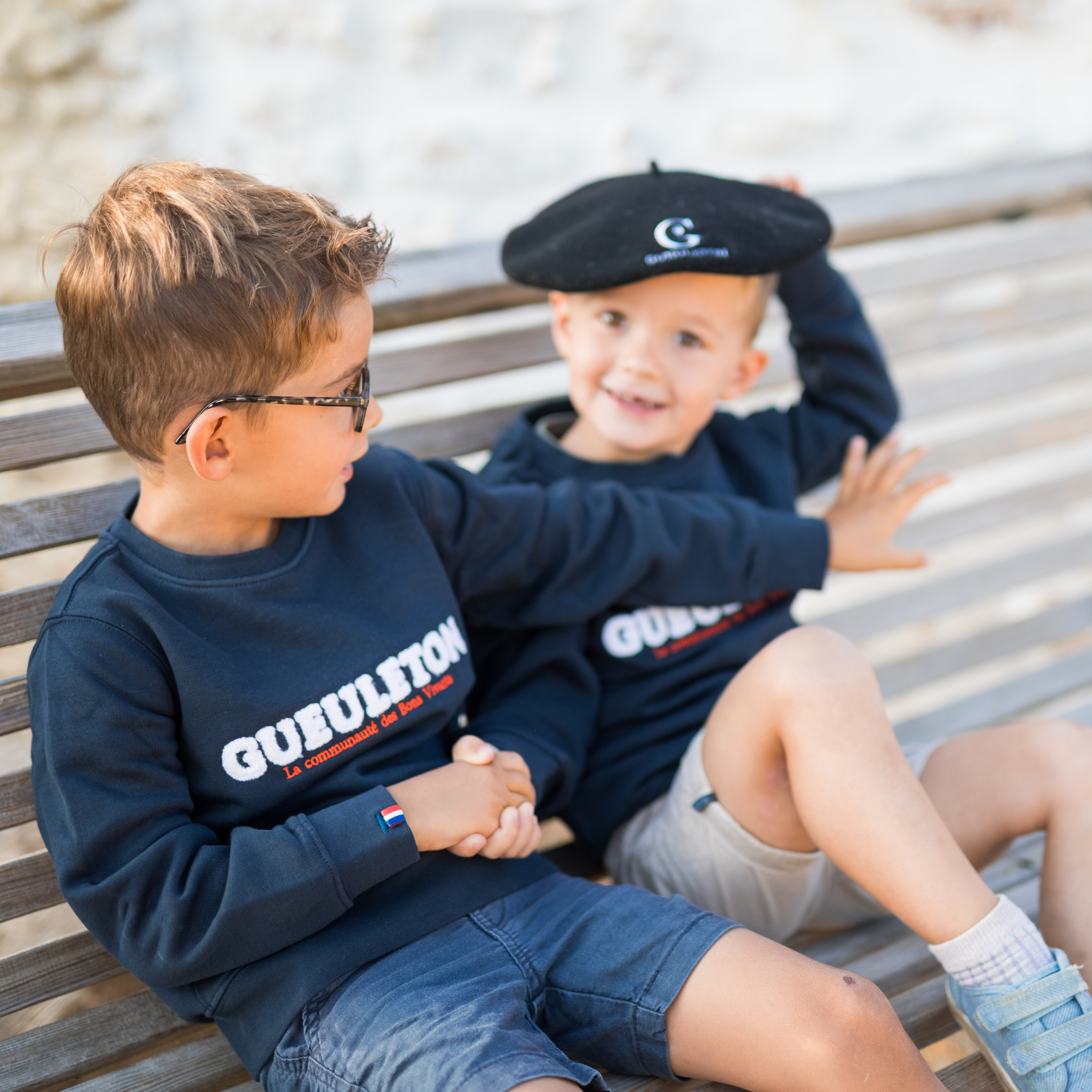 Deux enfants portant des sweats Gueuleton Marine, l'un avec un béret Gueuleton - Gueuleton