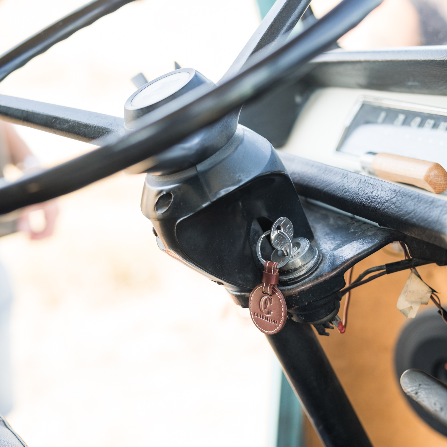 Porte-clés en cuir Gueuleton accroché à un volant de voiture vintage - Gueuleton