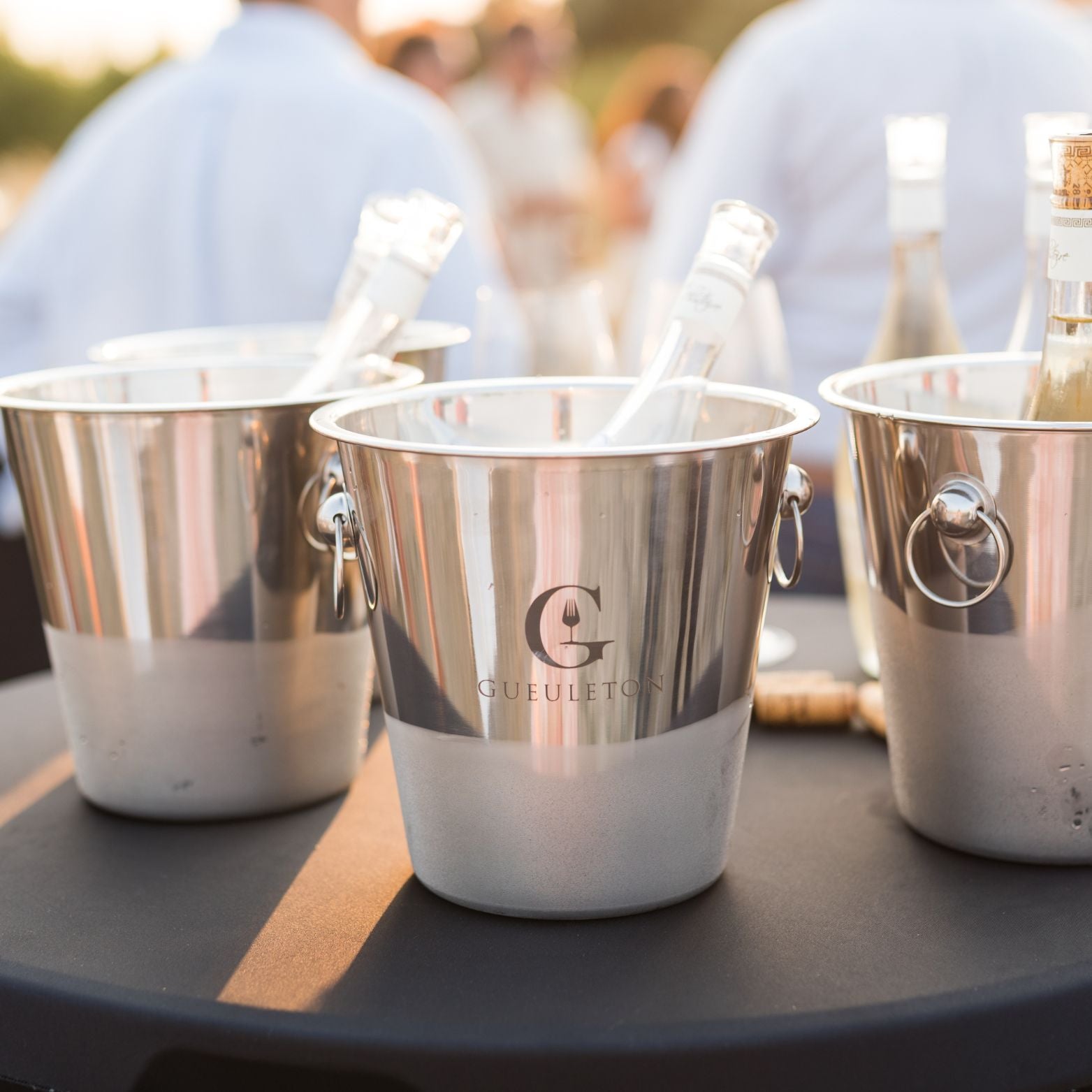 Seau à champagne inox Gueuleton sur table d’extérieur pendant un apéritif convivial